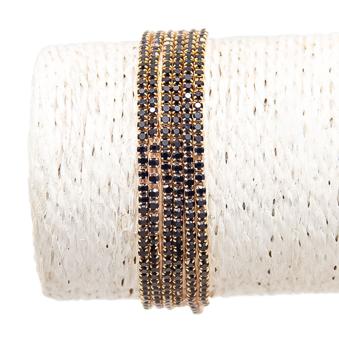 Pulseras doradas con piedras oscuras